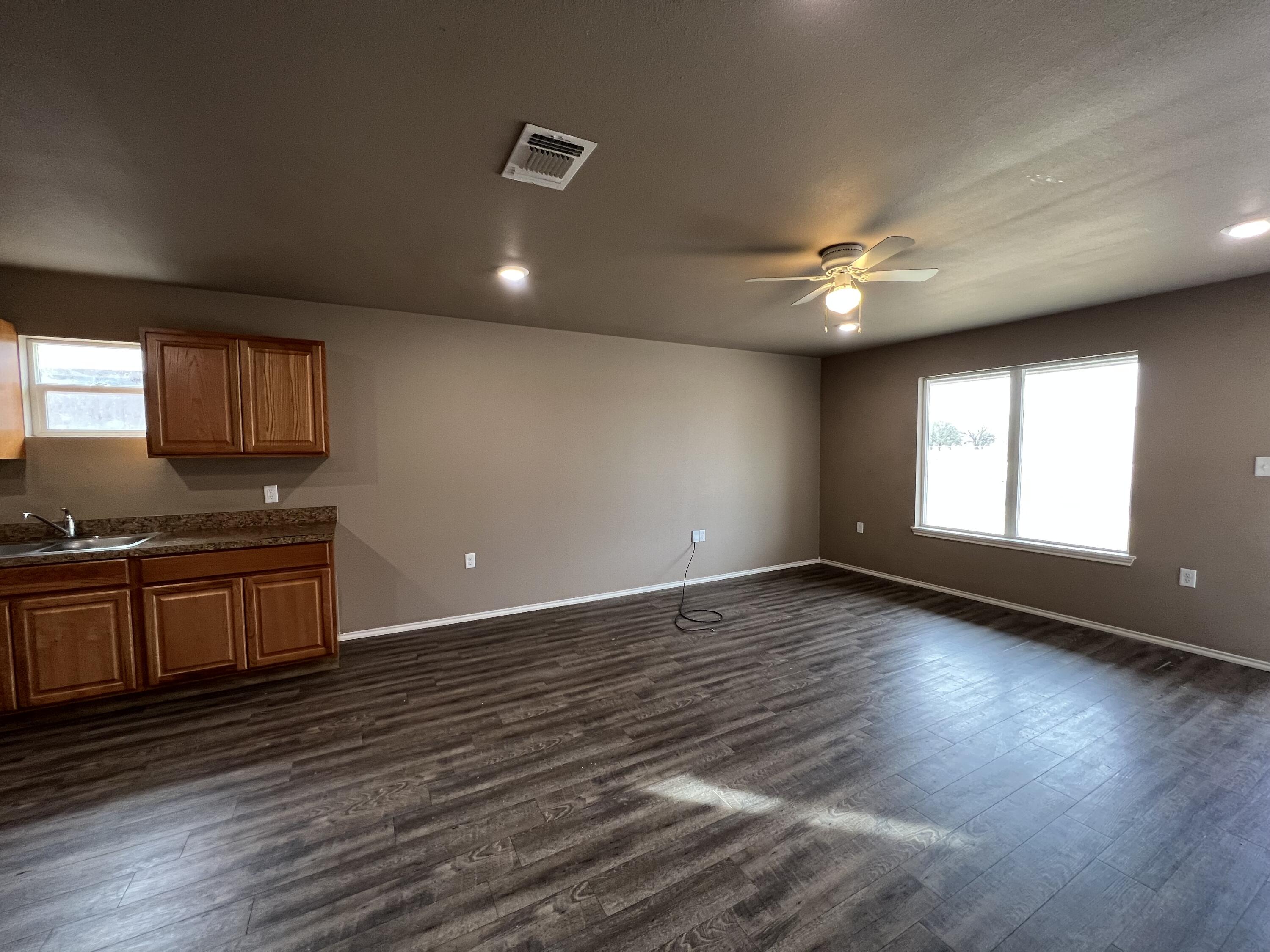 2914 East Cornell Street Lubbock, TX 79403 - Photo 2 of 18 a view of an empty room with window and wooden floor