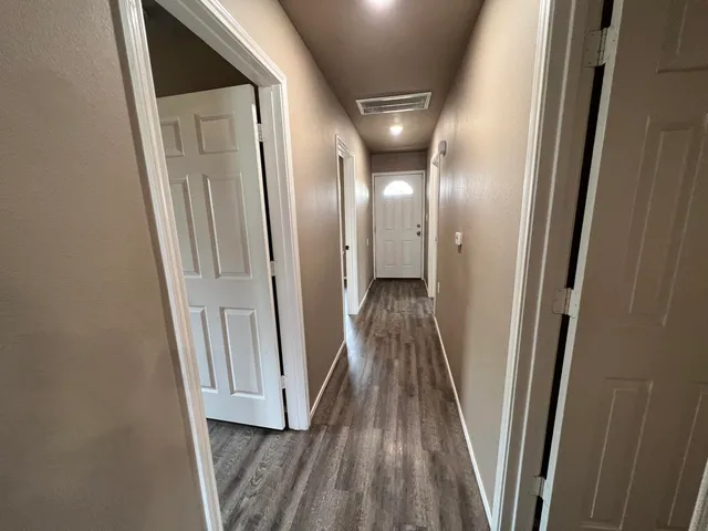 a view of a hallway with wooden floor and staircase