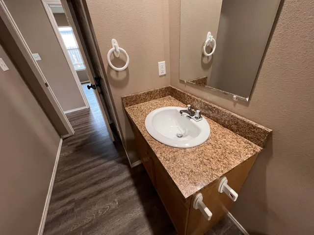 a bathroom with a granite countertop sink and a mirror