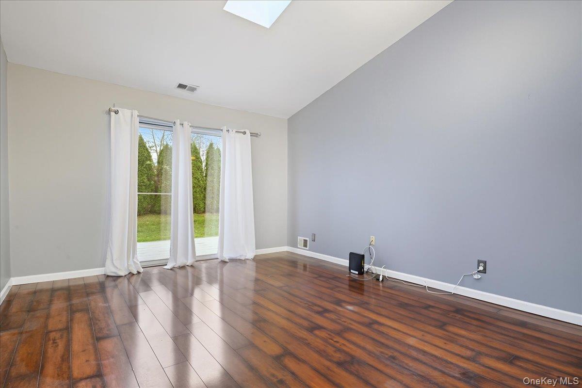 23 Sandy Hill Road Commack, NY 11725 - Photo 11 of 24 a view of an empty room with wooden floor and a window