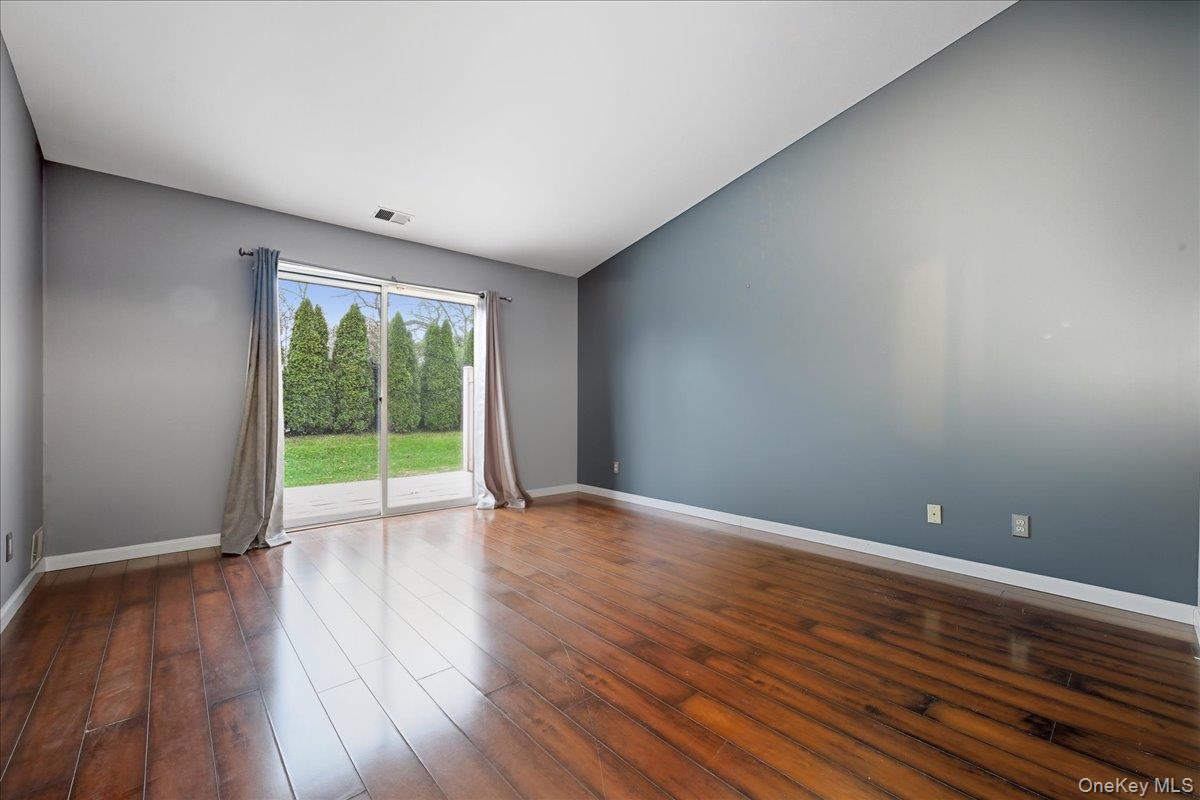 23 Sandy Hill Road Commack, NY 11725 - Photo 13 of 24 a view of an empty room with wooden floor and a window
