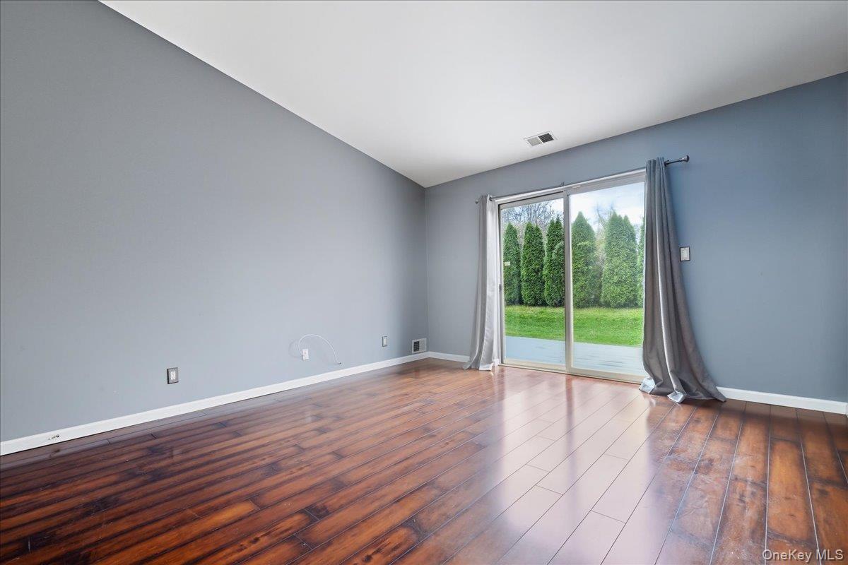 23 Sandy Hill Road Commack, NY 11725 - Photo 14 of 24 a view of an empty room with wooden floor and a window