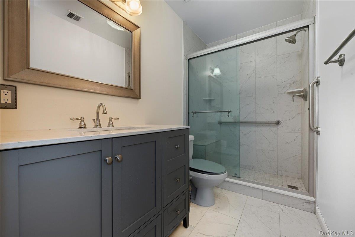 23 Sandy Hill Road Commack, NY 11725 - Photo 16 of 24 a bathroom with a shower sink vanity and mirror
