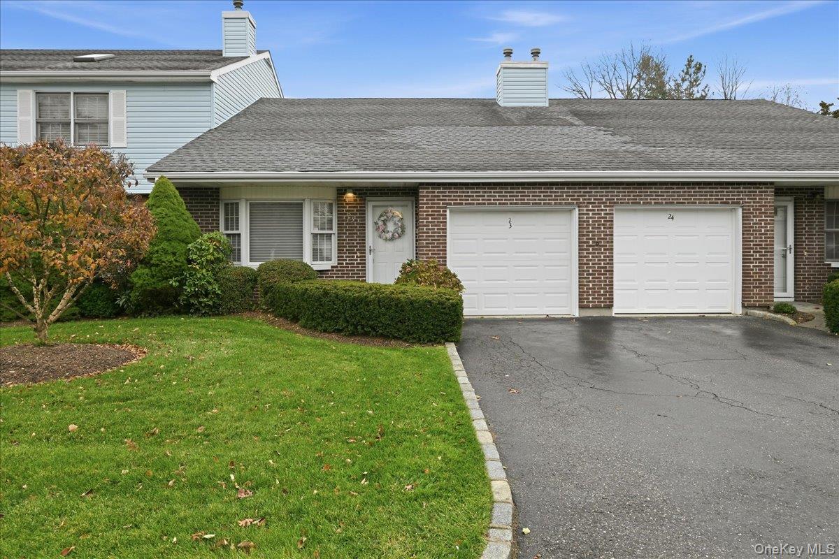 23 Sandy Hill Road Commack, NY 11725 - Photo 4 of 24 a front view of a house with a yard and garage