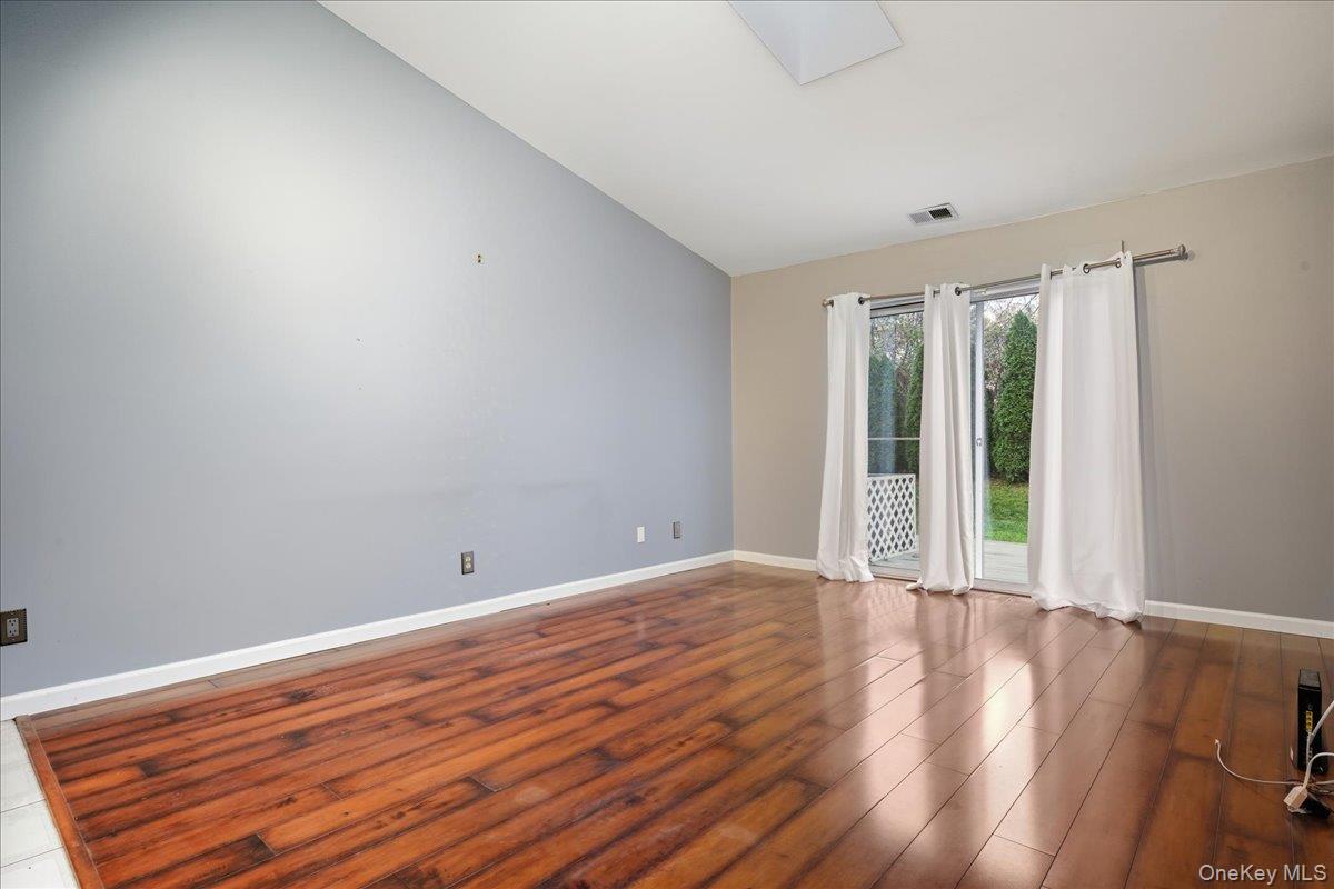 23 Sandy Hill Road Commack, NY 11725 - Photo 10 of 24 a view of an empty room with wooden floor and a window