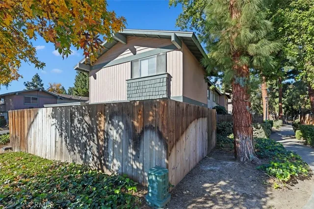 a view of a house with a small yard and wooden fence