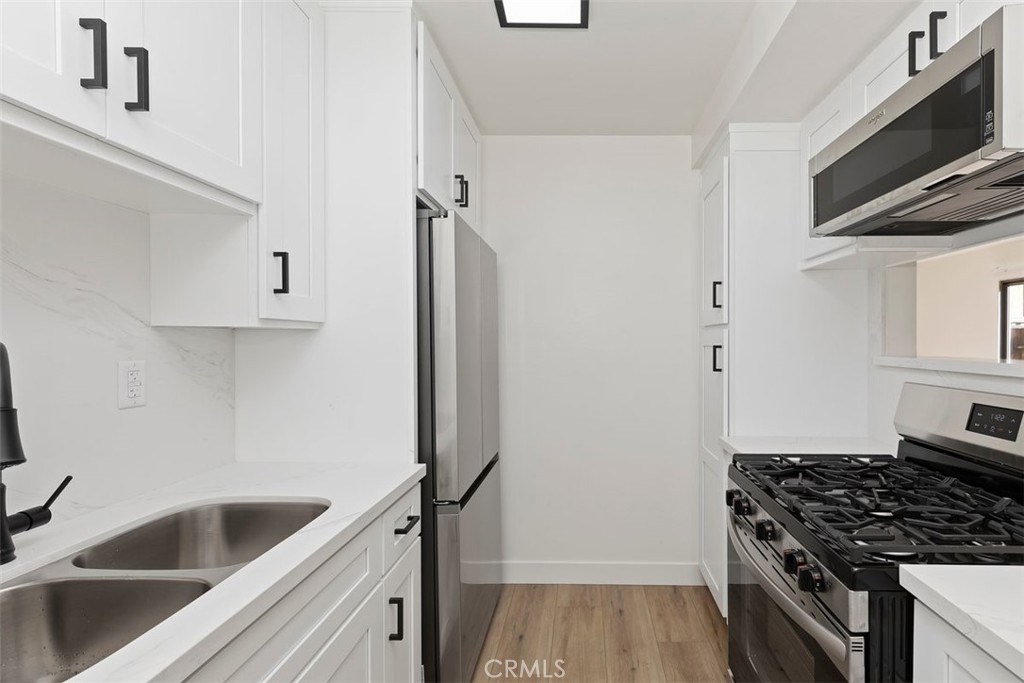 4807 Jackson Street, Unit D Riverside, CA 92503 - Photo 6 of 38 a kitchen with stainless steel appliances granite countertop a sink and a stove top oven