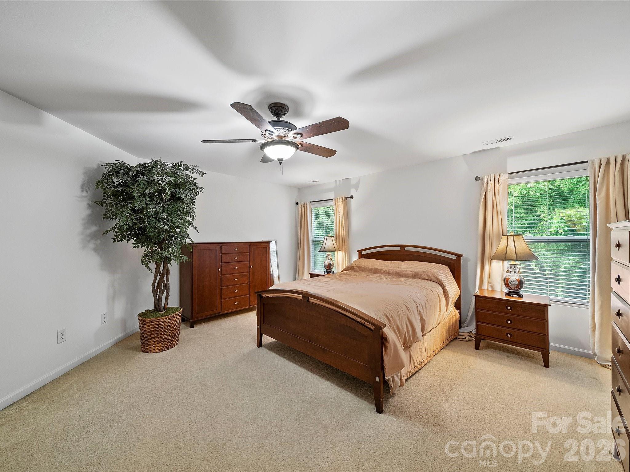 2306 Nettleton Court Matthews, NC 28105 - Photo 19 of 34 a spacious bedroom with a bed and a chandelier