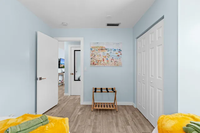 a bedroom with two beds and a potted plant