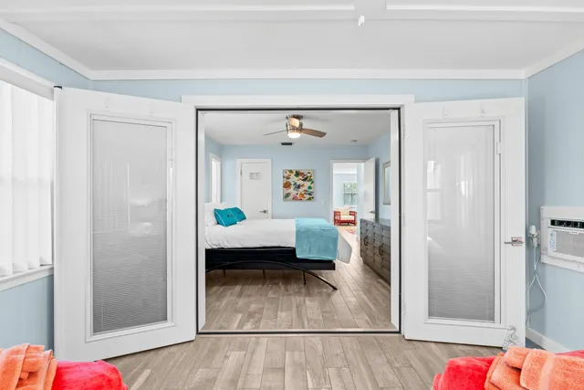a bedroom with a bed chandelier and a window