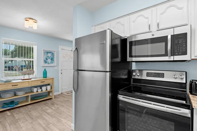a kitchen with stainless steel appliances granite countertop a refrigerator sink and stove