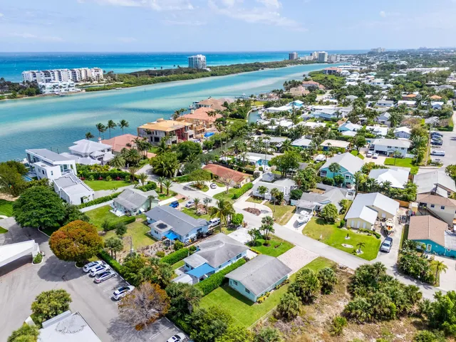 an aerial view of a city with lots of residential buildings ocean and mountain view in back