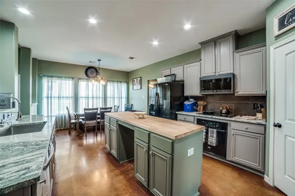 a kitchen with sink a microwave and cabinets