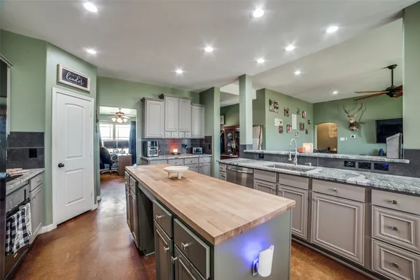 a kitchen with stainless steel appliances granite countertop counter space and wooden floors