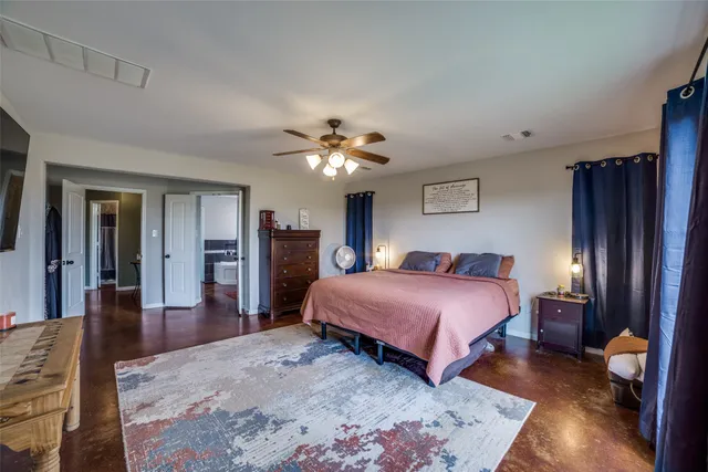 a spacious bedroom with a bed and a chandelier