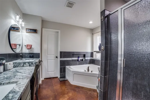 a bathroom with a bathtub sink and mirror