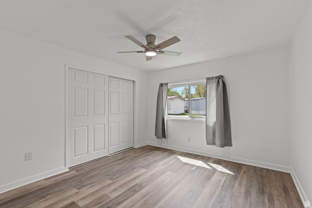 350 West 800 South, Unit 2 Logan, UT 84321 - Photo 7 of 22 Unfurnished bedroom featuring a closet, light wood-type flooring, and a ceiling fan