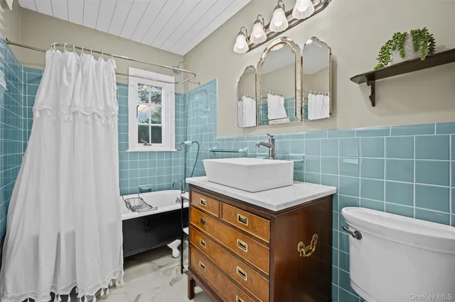 a bathroom with a sink a toilet and shower curtain