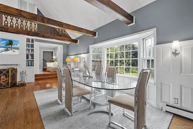 a dining room with furniture a fireplace and wooden floor