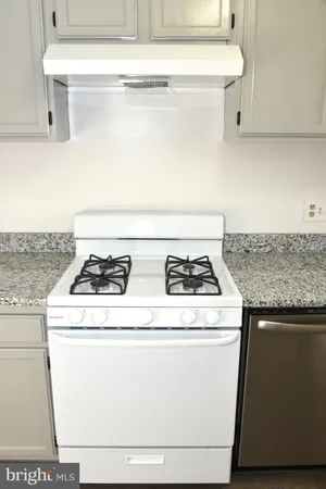 a white stove top oven sitting inside of a kitchen