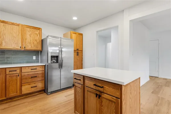 a kitchen with stainless steel appliances a refrigerator and wooden cabinets