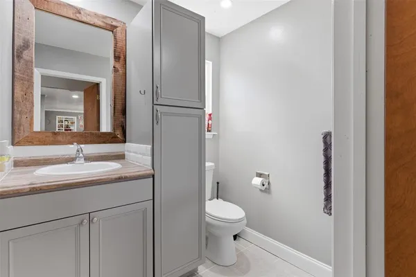 a bathroom with a toilet a sink and mirror