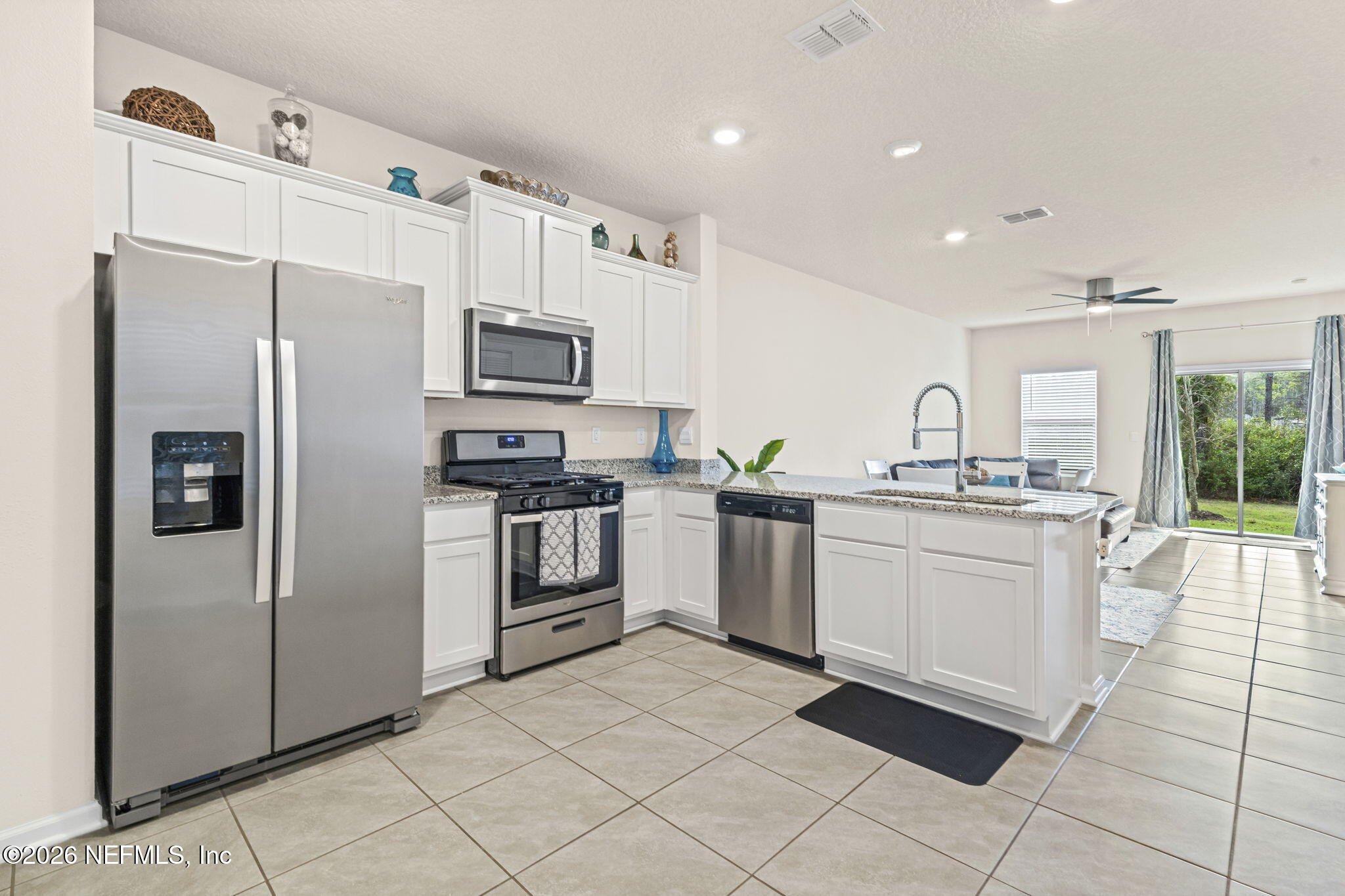 349 Coastline Way Street St. Augustine, FL 32092 - Photo 3 of 16 a kitchen with white cabinets and stainless steel appliances