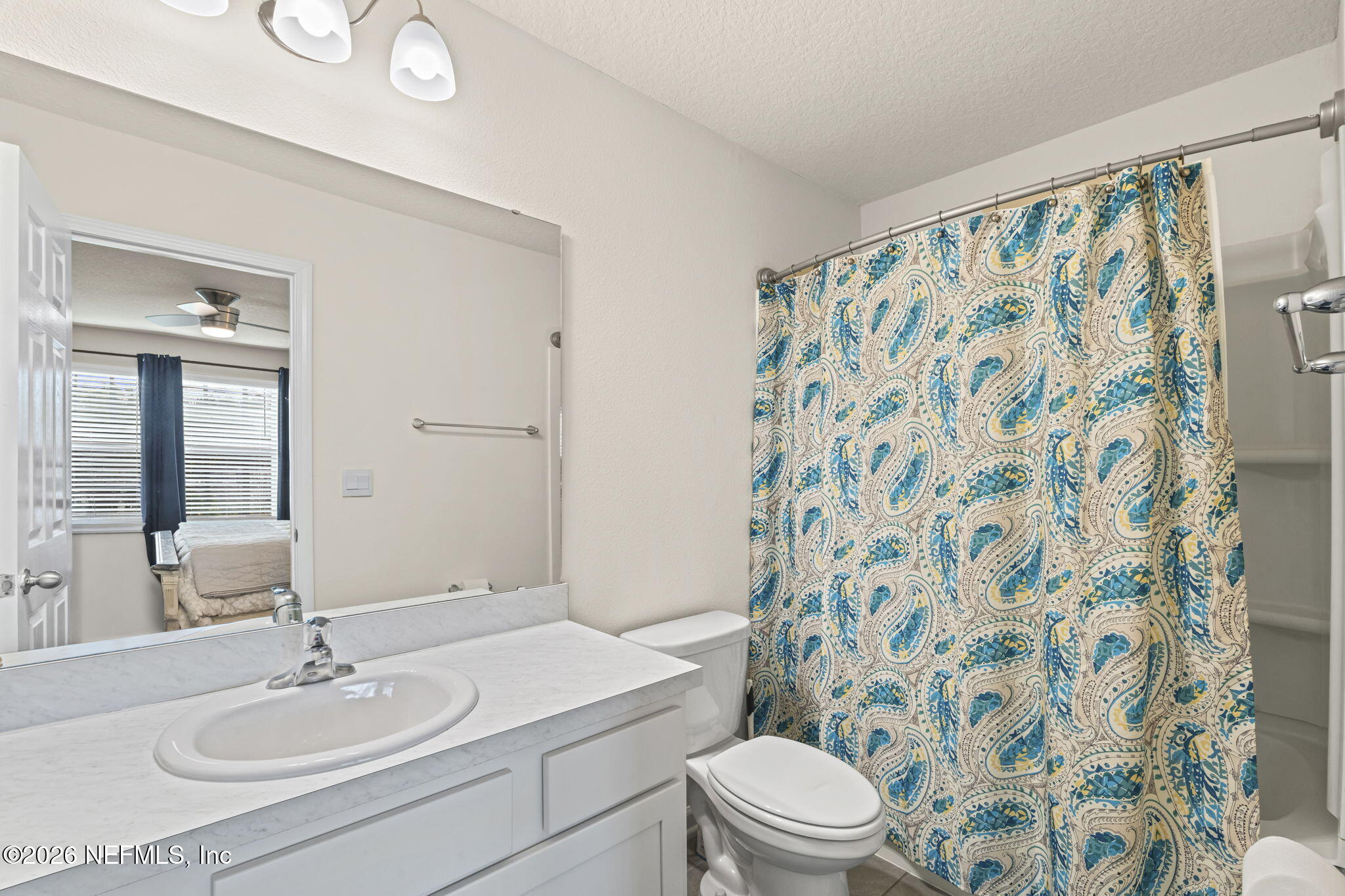 349 Coastline Way Street St. Augustine, FL 32092 - Photo 8 of 16 a bathroom with a sink toilet a mirror and shower curtain