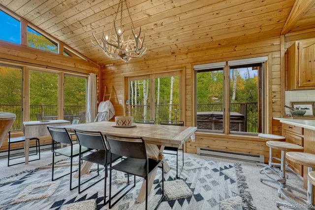 a view of a patio with table and chairs with wooden floor and fence