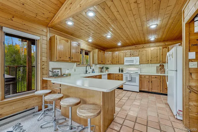 a large kitchen with stainless steel appliances granite countertop a sink and cabinets