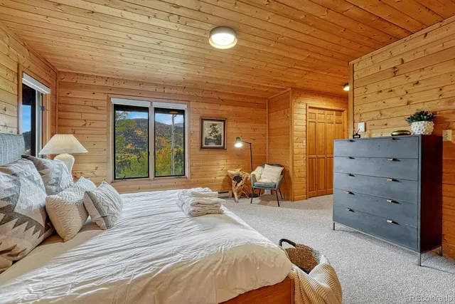 a bedroom with a bed a mirror and window