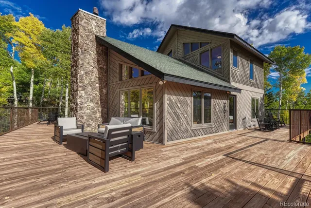 a view of a patio with dining table and chairs with wooden floor and fence