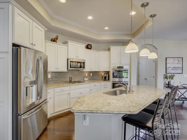 a kitchen with stainless steel appliances granite countertop a sink refrigerator and cabinets
