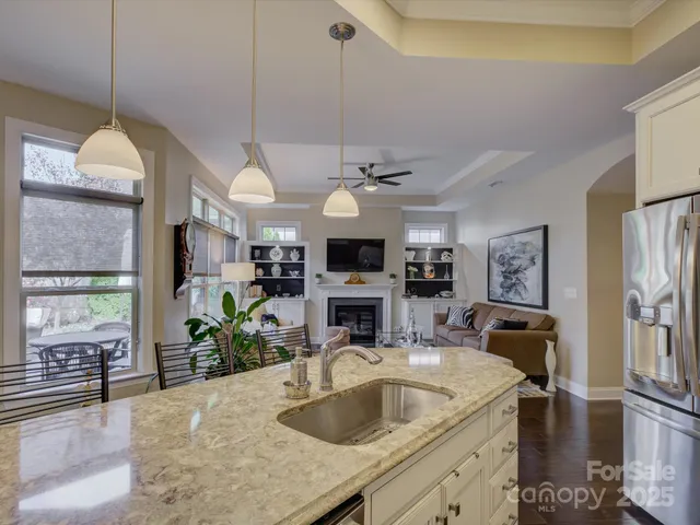 a kitchen with stainless steel appliances granite countertop white cabinets a stove a microwave and a sink