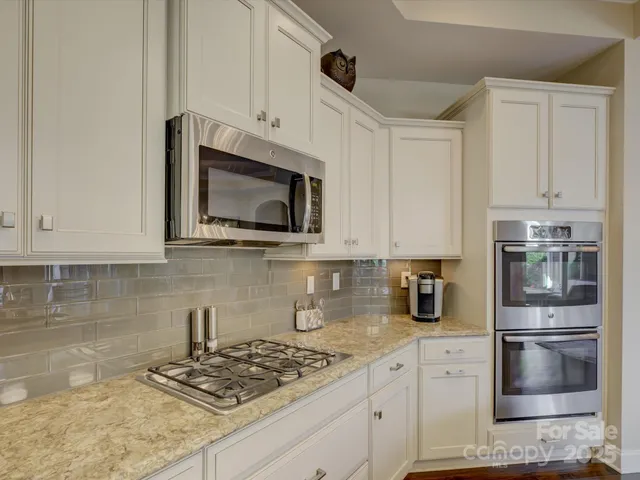 a kitchen with granite countertop a sink a counter top space and living room view