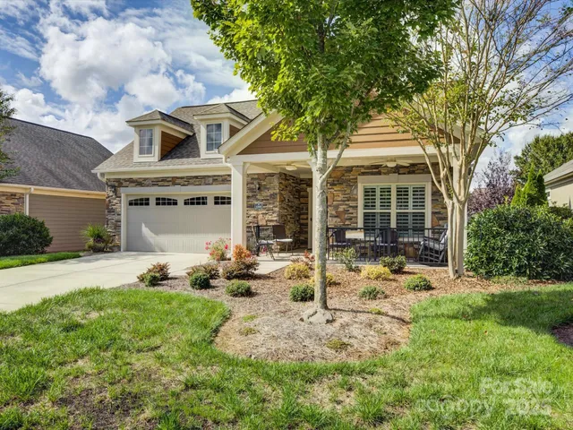 a front view of a house with yard patio and green space