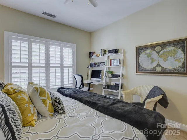 a bedroom with a bed a couch and a large window