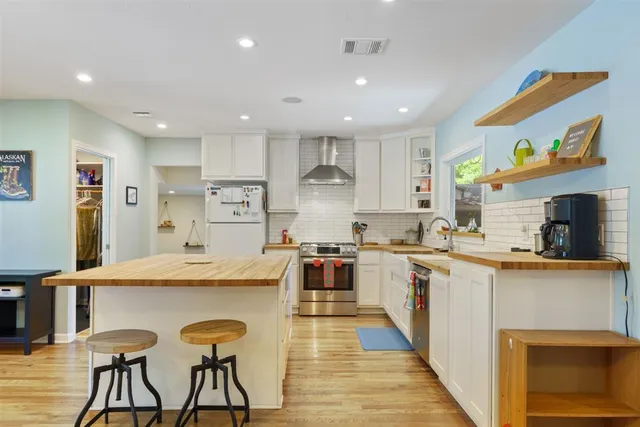a large kitchen with stainless steel appliances granite countertop a stove and a refrigerator