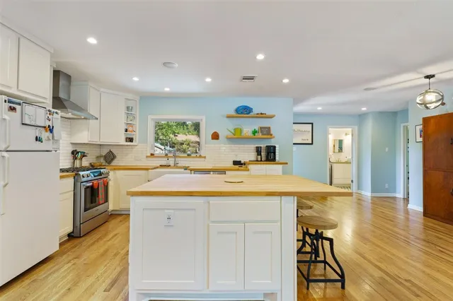 a kitchen with kitchen island a sink appliances and cabinets