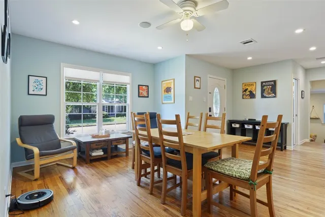 a view of a dining room with furniture a rug and wooden floor