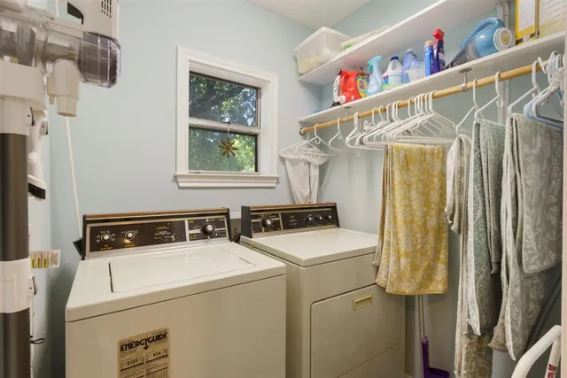 a bedroom with a large bed a chandelier and windows