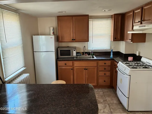 a kitchen with a stove a refrigerator and a sink