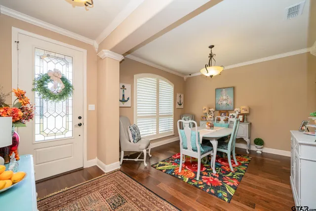 a dining room with wooden floor a chandelier a wooden table and chairs
