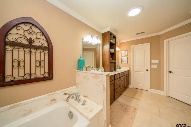 a bathroom with a double vanity sink mirror and bathtub