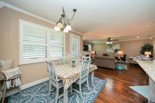 a dining room with wooden floor and chandelier