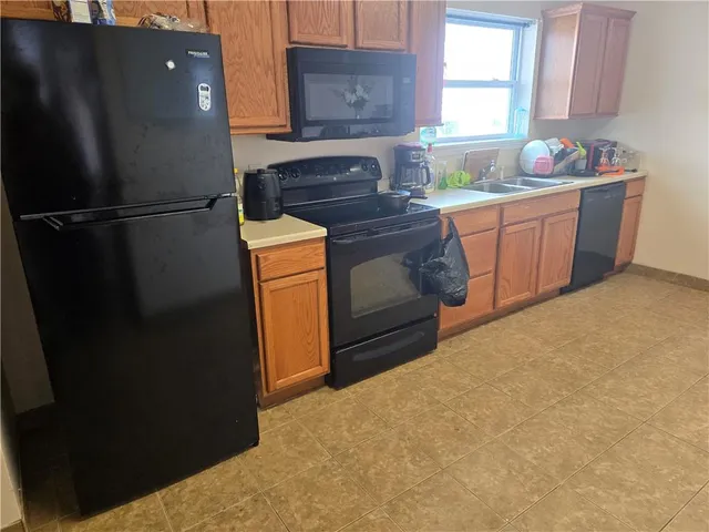 a kitchen with stainless steel appliances granite countertop a refrigerator a sink a stove and dishwasher