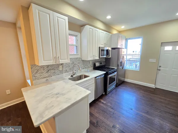a kitchen with granite countertop a refrigerator stove and sink