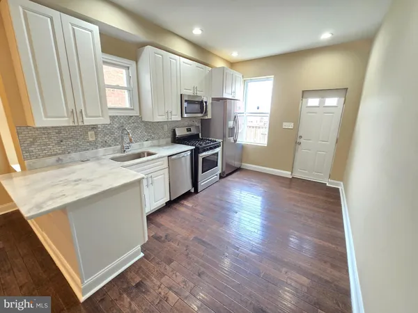 en empty room with wooden floor and mirror