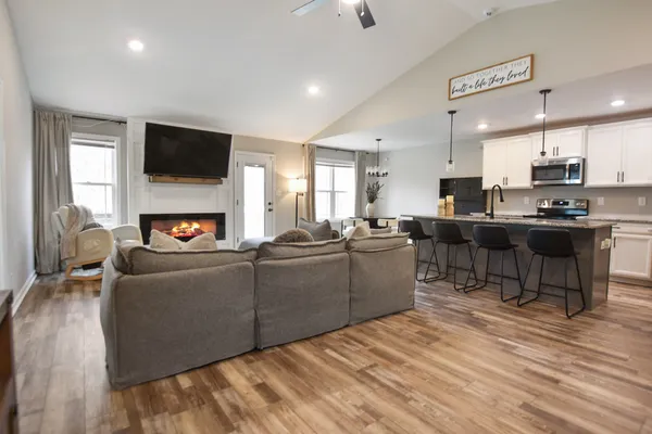 a living room with furniture a flat screen tv and kitchen view