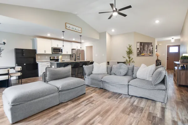 a living room with furniture kitchen view and a chandelier